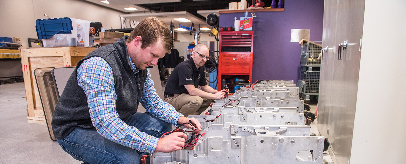 A student and faculty member calibrate autonomous farming equipment.